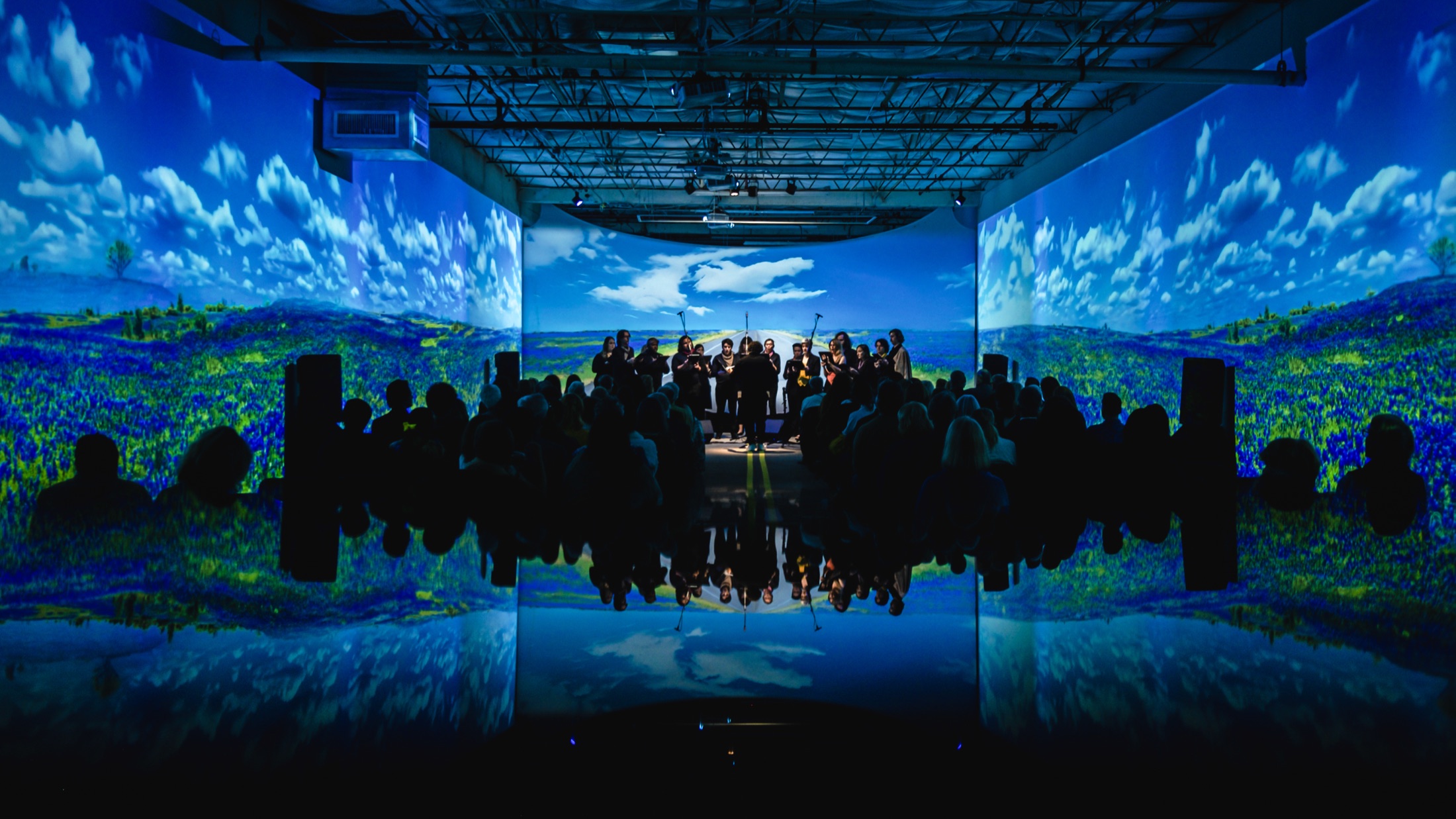 Verdigris Ensemble performing in a blue immersive landscape projection