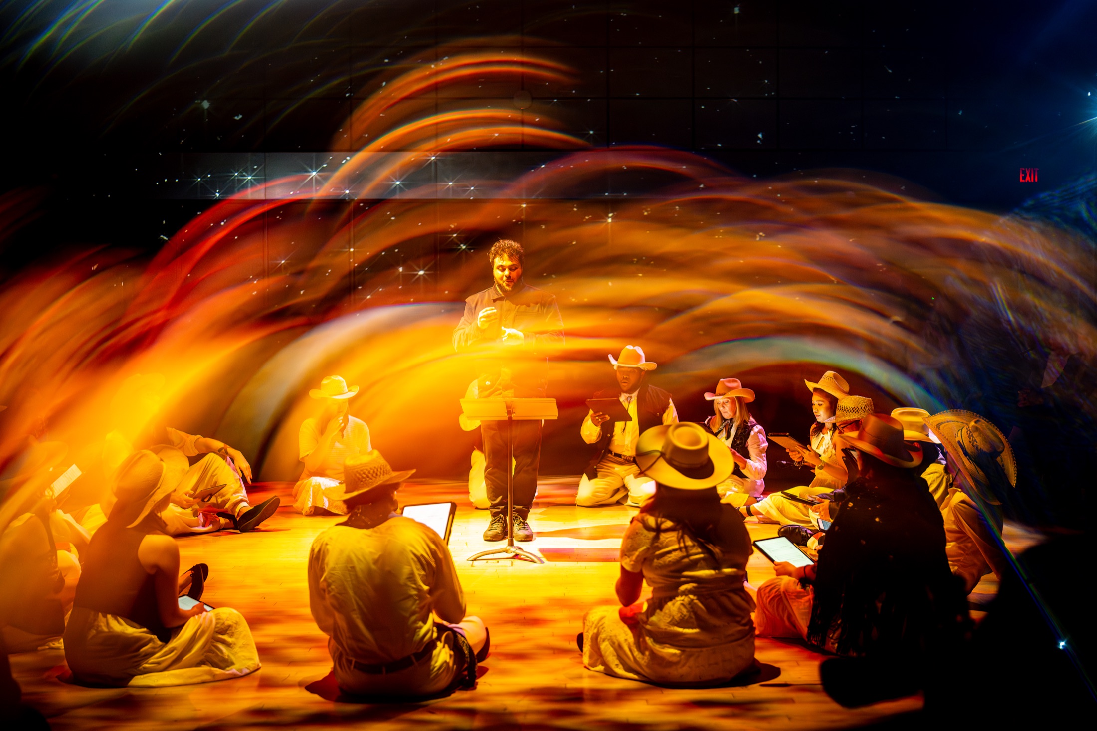 Sam surrounded by singers and a warm arc of light in A Western