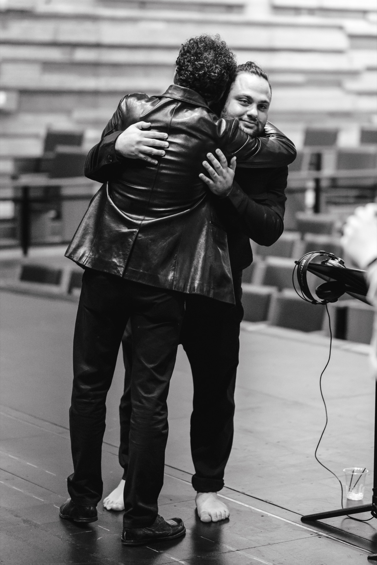 Two SHAMS collaborators embracing backstage in black and white