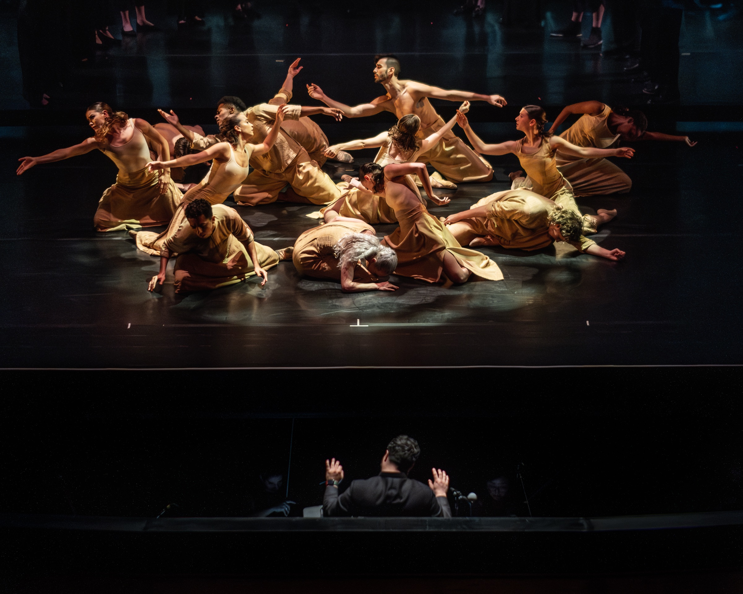 Dancers arranged in a circle during SHAMS with Sam Brukhman conducting below the stage